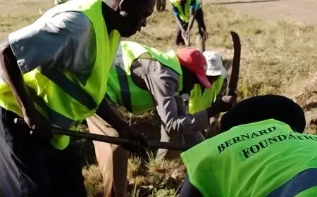 Volunteers wearing Bernard Karanja Foundation reflector vests digging and planting trees
